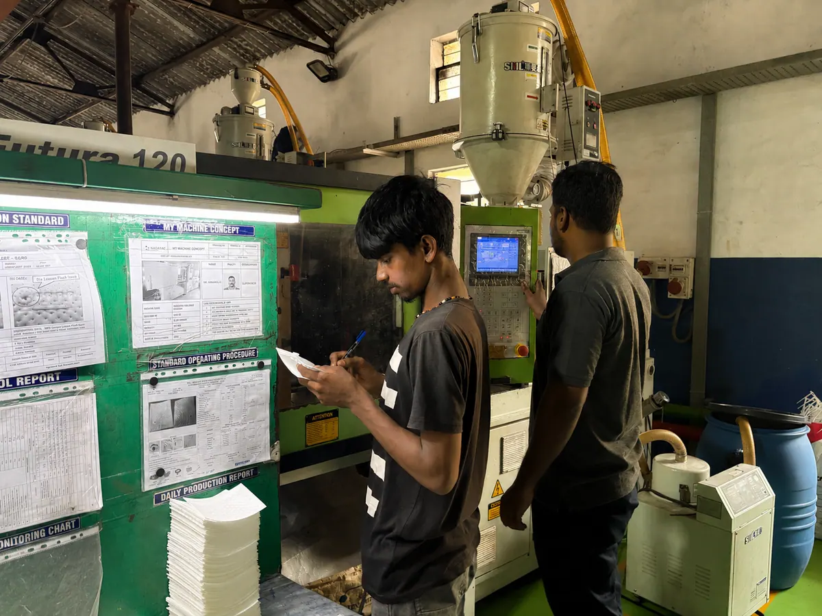 Nagasae operators checking an injection moulding machine and production records
