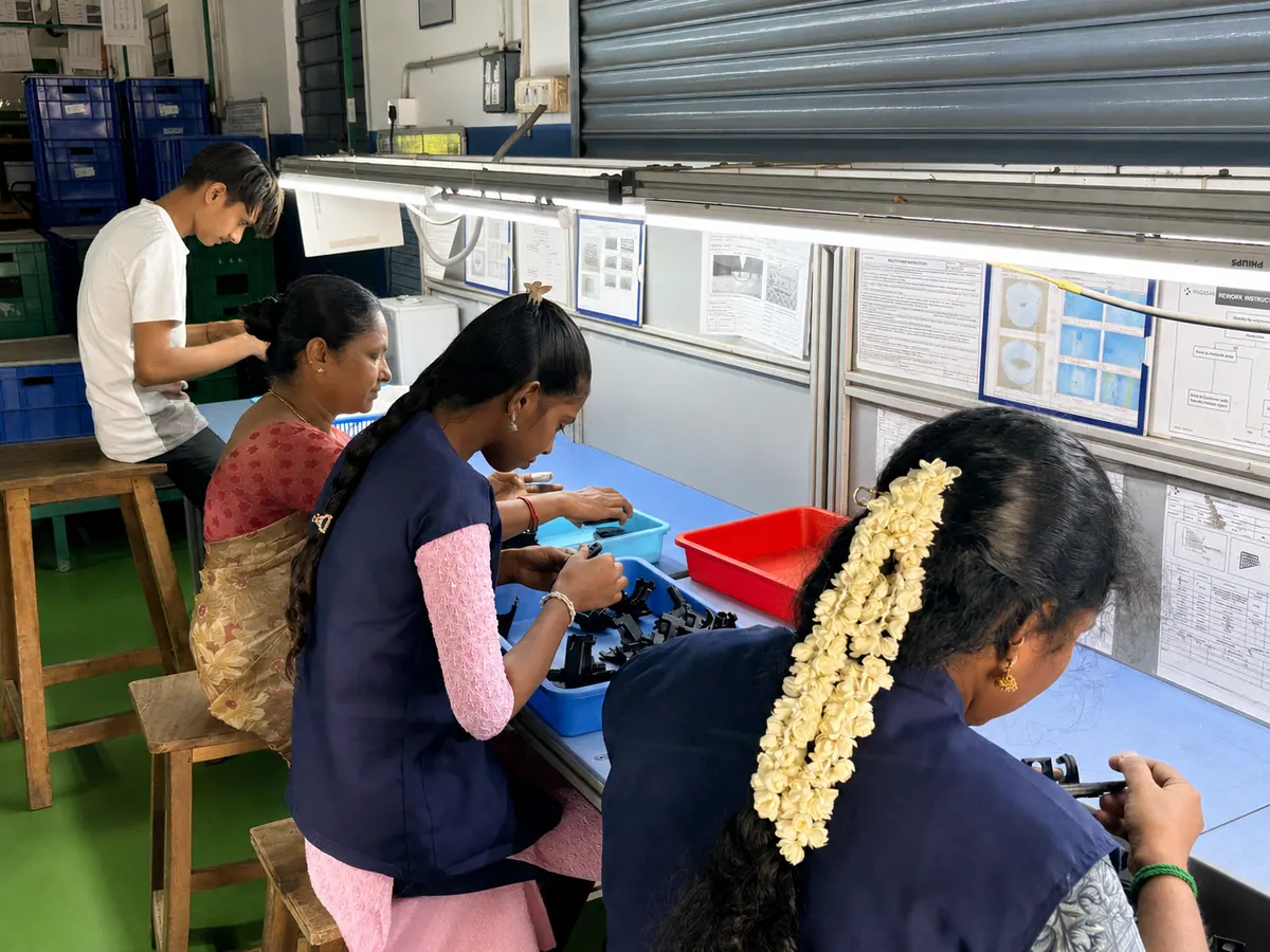 Nagasae team members inspecting plastic components at a quality workbench